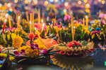 Festival Loy Krathonk. lidé kupují květinovou výzdobu, kterou se světlem svíčky pouštějí po vodním